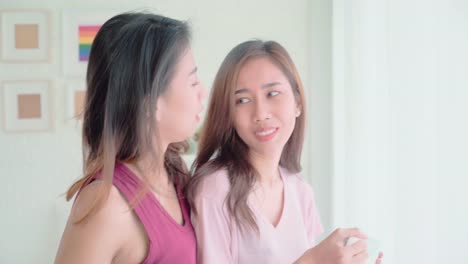 Young-Asian-women-lesbian-happy-couple-talking-and-drinking-coffee-in-bedroom-at-home,-enjoy-love-moment-while-lying-on-bed-when-relaxed-in-morning.-Lifestyle-LGBT-couple-together-indoors-concept.