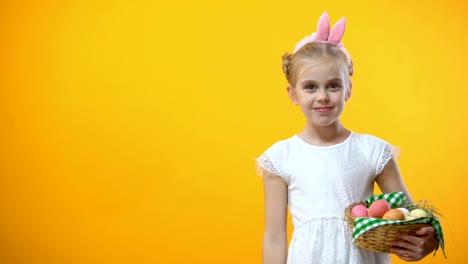 Happy-Easter-text,-adorable-schoolgirl-taking-pink-egg-from-basket-greeting-card