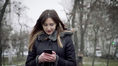 Junge-Frau-geht-mit-Handy-und-kommuniziert-in-sozialem-Netzwerk-in-Zeitlupe