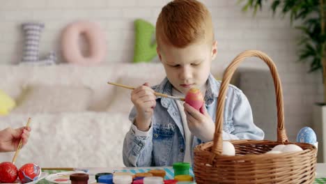 Niño-enfocado-pintura-huevo-de-Pascua