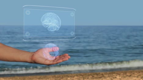 Manos-masculinas-en-la-playa-con-cerebro-holograma