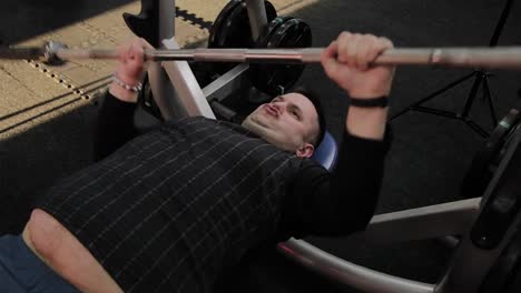 Cheerful-fat-man-performs-the-wrong-bench-press-in-the-gym