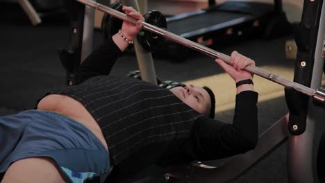 Cheerful-fat-man-performs-the-wrong-bench-press-in-the-gym