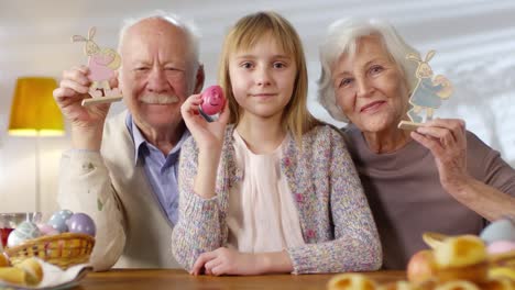 Chica-y-abuelos-sosteniendo-juguetes-de-Pascua