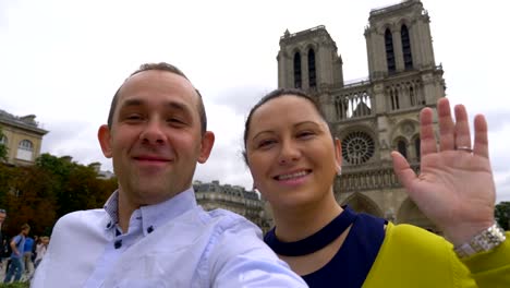 Couple-taking-selfie-with-a-view-of-Notre-Dame-Cathedral-in-Paris-in-4k-slow-motion-60fps