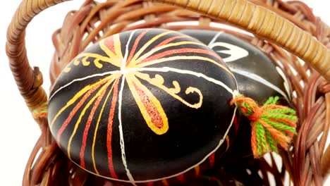 decorative-basket-with-painted-Easter-eggs-on-white-background