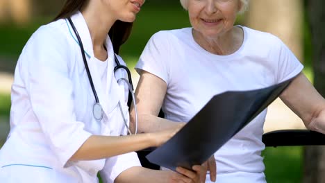 Médico-experimentado-explicando-la-radiografía-de-la-columna-vertebral-al-paciente-discapacitado,-proceso-de-rehabilitación