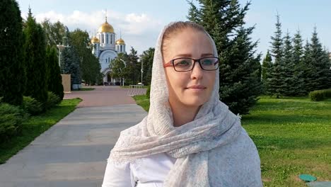 Orthodoxe-Frau-zu-Fuß-im-Park-auf-dem-Hintergrund-der-Kirche