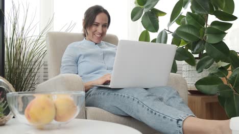 Lächelnde-Frau-mit-Laptop-zu-Hause