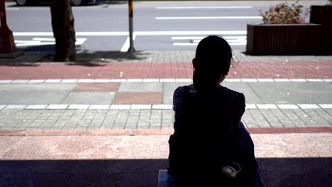 Silhouette-of-a-little-girl-sitting-at-the-bus-stop.