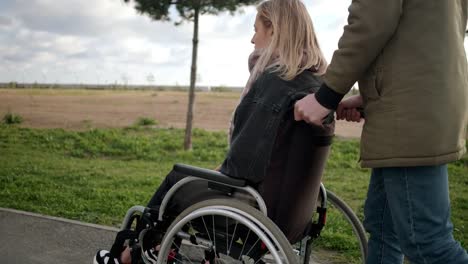 Man-walking-with-handicapped-girl-in-wheelchair