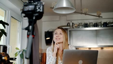 Happy-professional-young-Caucasian-fashion-blogger-filming-new-vlog-video-with-camera-at-home-kitchen-slow-motion.