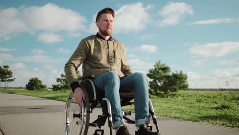 Male-patient-in-wheelchair-is-walking-in-park-area-in-warm-sunny-weather