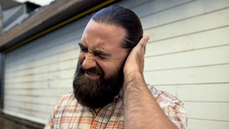 Bearded-man-rubbing-ear-to-relieve-pain,-infection-symptom,-ruptured-eardrum