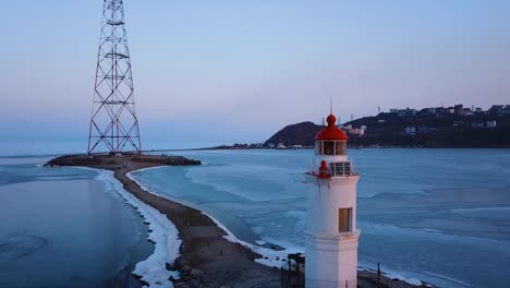 Aerial-winter-view-of-the-Tokarevskiy-lighthouse---one-of-the-oldest-lighthouses-in-the-Far-East,-still-an-important-navigational-structure-and-popular-attractions-of-Vladivostok-city,-Russia.