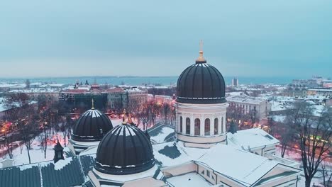 Filmische-Luftaufnahme-von-Kuppel-und-orthodoxen-Kreuz-auf-Turm-der-Verklärung-Kathedrale-in-Odessa-am-Winterabend.