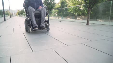 4k-resolution-closeup-follow-from-front-of-a-man-on-electric-wheelchair-driving-on-a-street.-Accessibility-concept