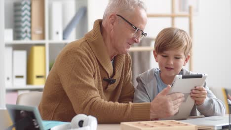 Retired-Man-Using-Tablet-with-Help-of-Teenager