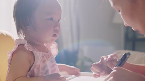 Asian-Baby-Girl-Aprender-a-Usar-Tablet-con-Mamá