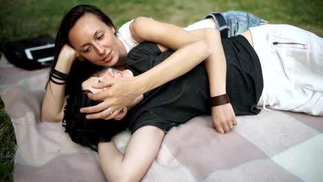 Sweet-lesbians-hugs-and-relaxing-on-cover-in-park