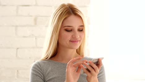 Portrait-of-Young-Woman-Browsing-Smartphone-in-Office