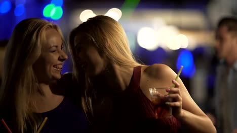 Bisexual-hot-ladies-hugging-and-laughing-on-dance-floor-at-nightclub-party