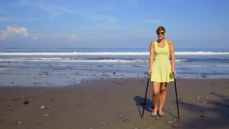 CLOSE-UP:-Girl-with-crutches-and-good-health-insurance-on-summer-beach-holidays