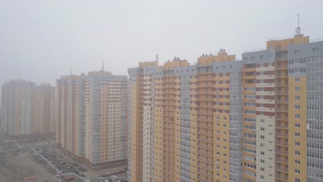 Vista-aérea.-Edificios-residenciales-high-rise-en-la-ciudad-en-la-niebla.-Amarillo-nuevo-casas-con-apartamentos-residenciales.-Constructoras-construyen-muchas-casas-nuevas-en-las-grandes-ciudades-en-venta-y-alquiler-de-inmuebles