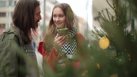 Young-happy-couple-using-smartphone-in-a-city.