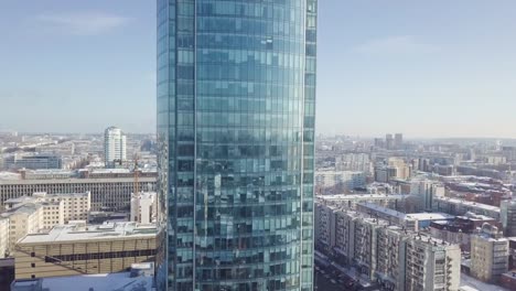 Top-view-of-a-skyscraper-and-modern-city-in-winter.-Gorgeous-skyscraper-in-the-sun