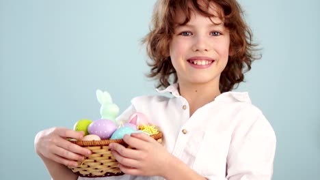 Feliz-Pascua-de-resurrección.-Un-niño-con-una-cesta-de-Pascua-sonriendo-alegremente.-Retrato-sobre-fondo-azul