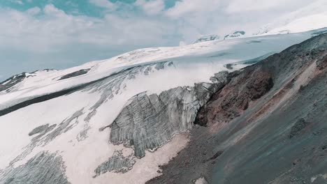 Toma-aérea-del-asombroso-paisaje-de-montañas-rocosas-nevadas-de-naturaleza