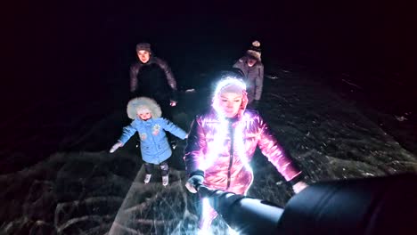 Familie-ist-Eislaufen-Nacht,-machen-Selfie.-Mutter,-Vater,-Tochter-und-Sohn-fahren-zusammen-auf-Eis-in-Rissen.-Im-freien-Winterspaß-für-Sportler-schönes-Winterwetter.-Menschen-auf-Schlittschuhen.