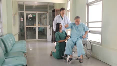 Doctor-and-nurse-reassuring-and-cheering-elderly-patients-in-wheelchair