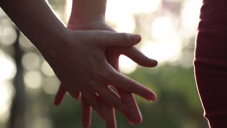 Close-up-of-hands-joining-together-with-sunlight-flare-in-the-background2.-Beautiful-romantic-moment-between-two-lovers