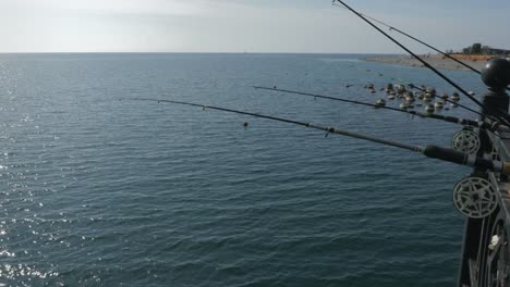 Cañas-de-pescar-y-pesca-equipos-en-el-muelle-junto-al-mar