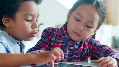 Multiethnic-Boy-and-Girl-Playing-on-Digital-Tablet