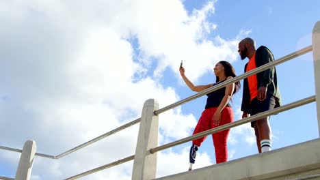 Couple-taking-selfie-with-mobile-phone-near-railing-4k