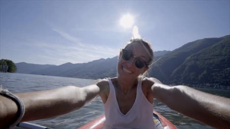 Young-woman-taking-selfie-portrait-in-red-canoe-on-mountain-lake--One-female-enjoying-Summer-vacations-having-fun-in-outdoor-activities--Slow-motion