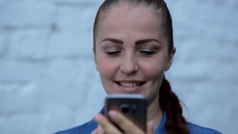 Portrait-of-young-beautiful-caucasian-woman-using-smart-phone-hand-hold-outdoor-in-the-city-night,-smiling,-face-illuminated-screenlight---social-network,-technology,-comunication-concept