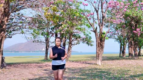 An-Asian-woman-jogging-in-natural-sunlight-in-the-morning.
She-is-trying-to-lose-weight-with-exercise.--concept-health-with-exercise.-Slow-Motion