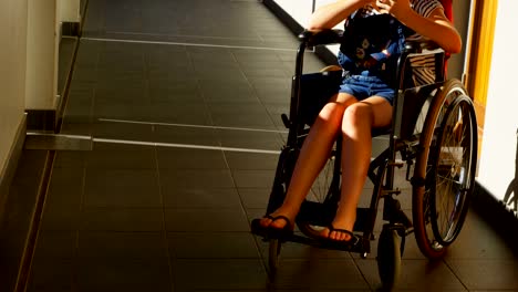 Disabled-schoolgirl-using-mobile-phone-in-the-corridor-4k