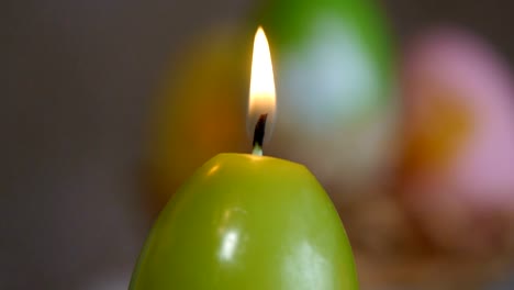 Candles-made-in-shape-of-easter-egg.-Green-candles.-Female-hand-lights-candles.