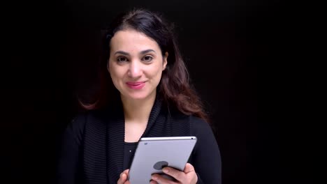 Closeup-portrait-of-young-attractive-caucasian-female-using-tablet-then-looking-at-camera-and-smiling