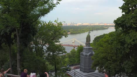 Aerial-view-of-the-Monument-to-Vladimir-the-Great,-the-Pedestrian-Bridge-and-the-Dnieper-River,-Kiev