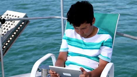 Junge-mit-digitalen-Tablet-Computer-auf-Yacht