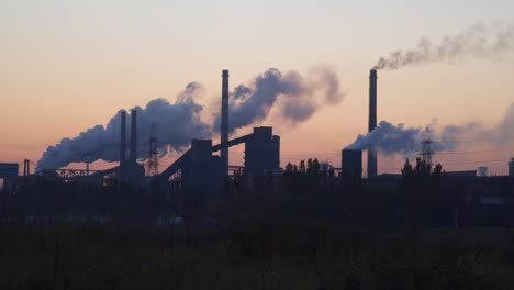 Rauch-aus-den-Röhren-einer-metallurgischen-Anlage-gegen-den-Himmel-bei-Sonnenaufgang