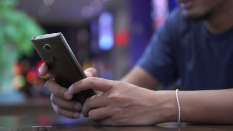 Close-up-hand-using-smartphone-in-cafe