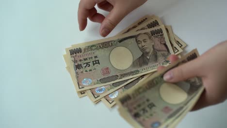 Hand-counting-ten-thousand-yen-banknote