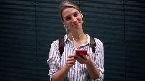 Efecto-de-cámara-lenta-de-alegre-meloman-femenino-escuchando-música-con-gran-volumen-usando-auriculares-en-el-área-de-publicidad